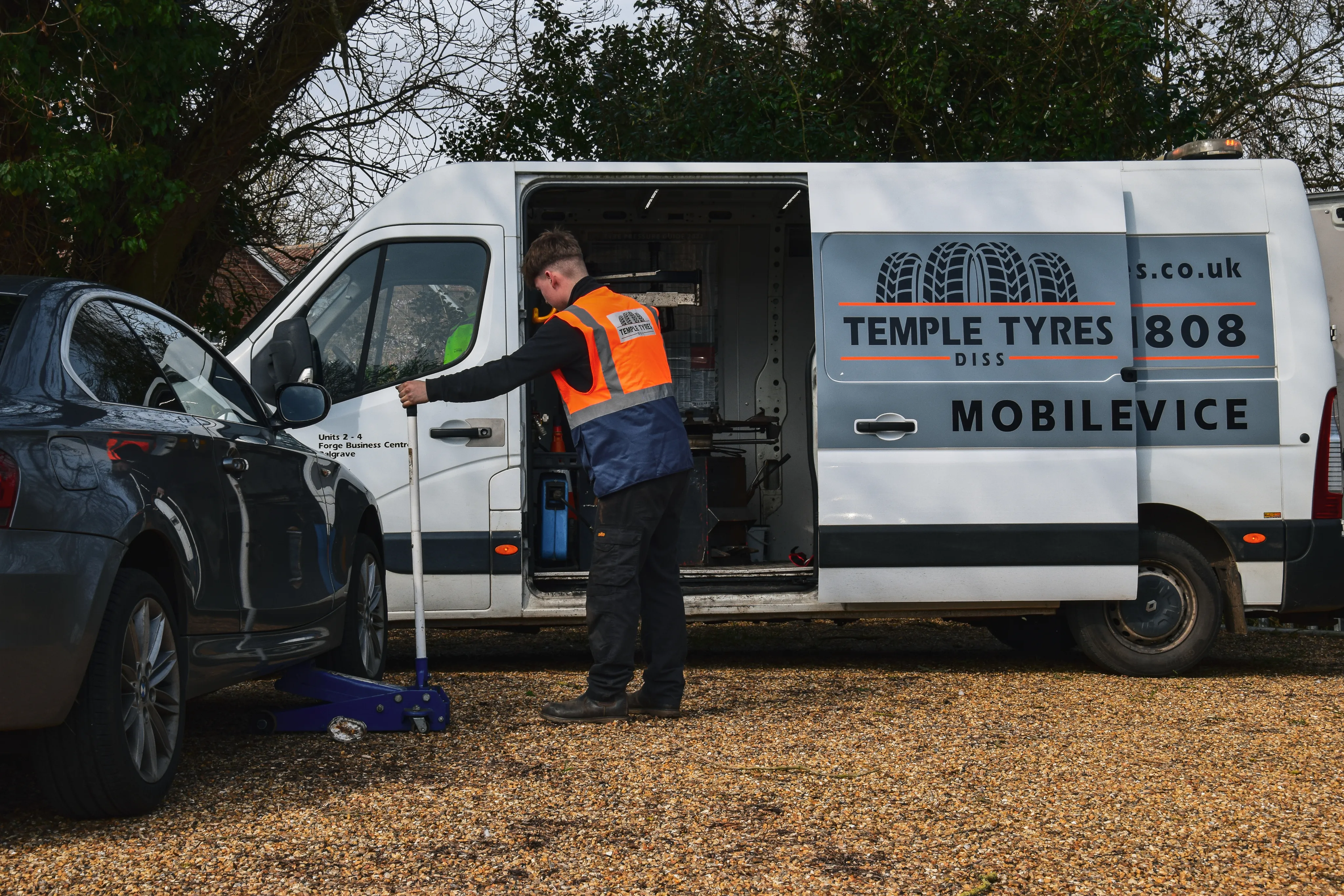 Technician performing mobile tyre fitting at roadside