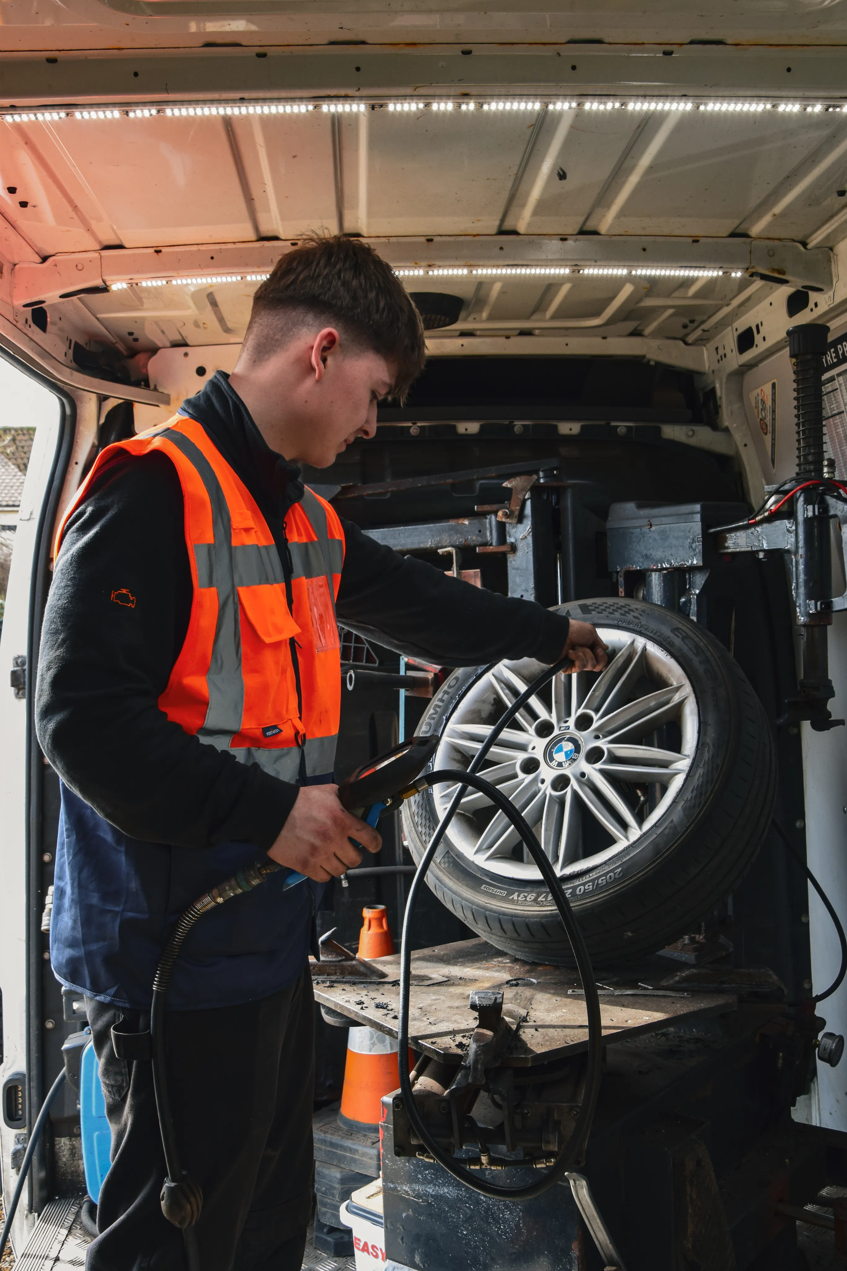 Technician fitting a tyre on a vehicle